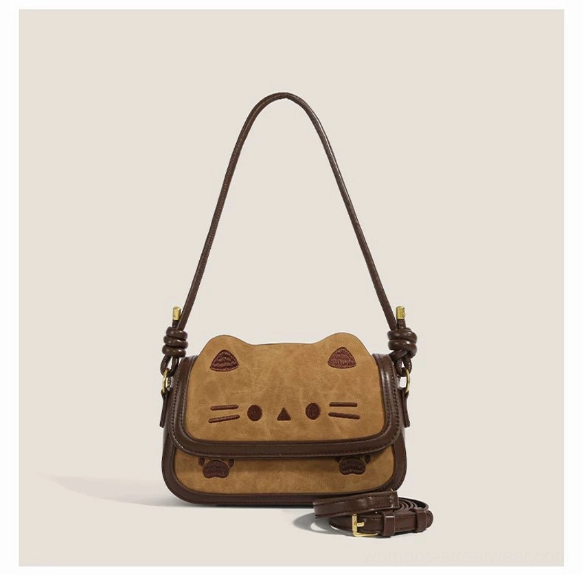Front view of caramel khaki kitty charm shoulder bag with embroidered cat eyes whiskers ears paws and coiled shoulder strap