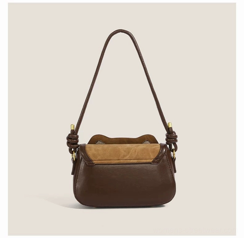 Rear three quarter view of khaki and dark brown kitty shoulder crossbody bag showing plain back panel and strap hardware