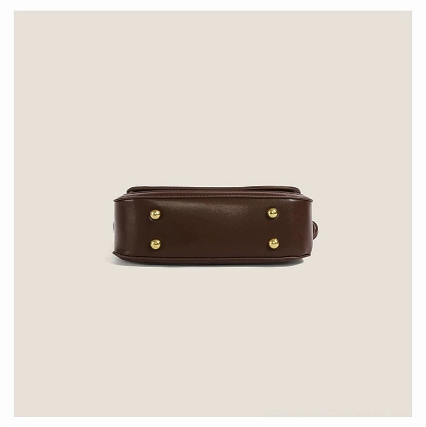 Bottom view of cinnamon kitty PU shoulder bag showing smooth dark brown base and four gold tone anti scratch metal studs