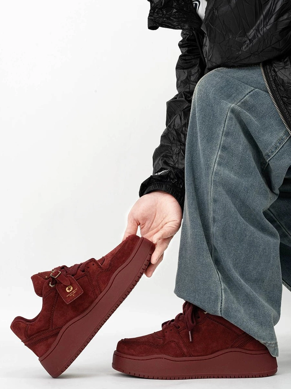 Claret burgundy suede-textured platform skate sneakers with tonal chunky sole styled beside loose blue denim jeans