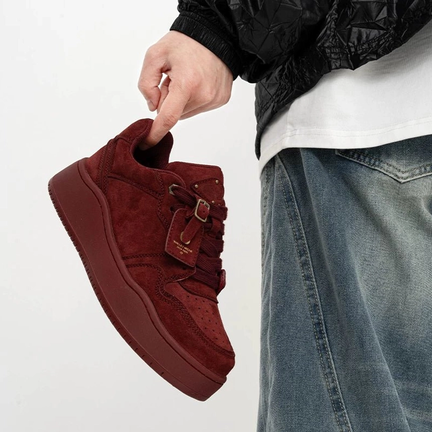 Angled close-up of claret burgundy retro nubuck platform skate sneakers with matching thick sole, wide laces and low-top silhouette