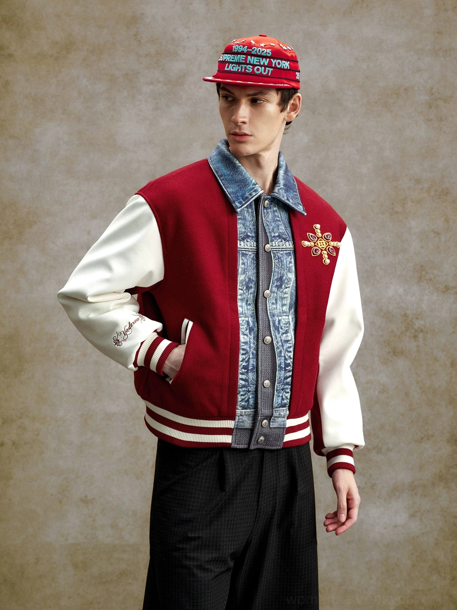Claret and white denim panel embroidered varsity bomber jacket worn with a graphic baseball cap, layered collar, chest embroidery, and striped ribbed cuffs