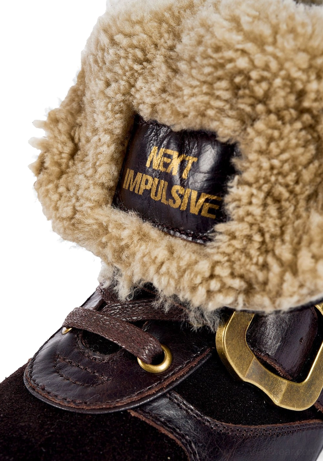 Close-up of tan shearling cuff, leather strap, and brass buckle on a dark brown western ankle boot