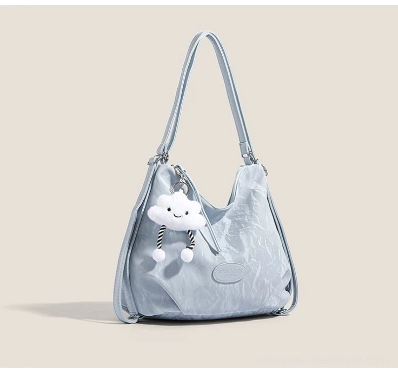 Light blue cloud charm crinkle convertible hobo shoulder bag with silver hardware and plush cloud pendant front three quarter view