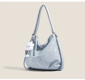 Light blue crinkle convertible hobo shoulder bag with cloud plush charm and adjustable silver strap side three quarter view