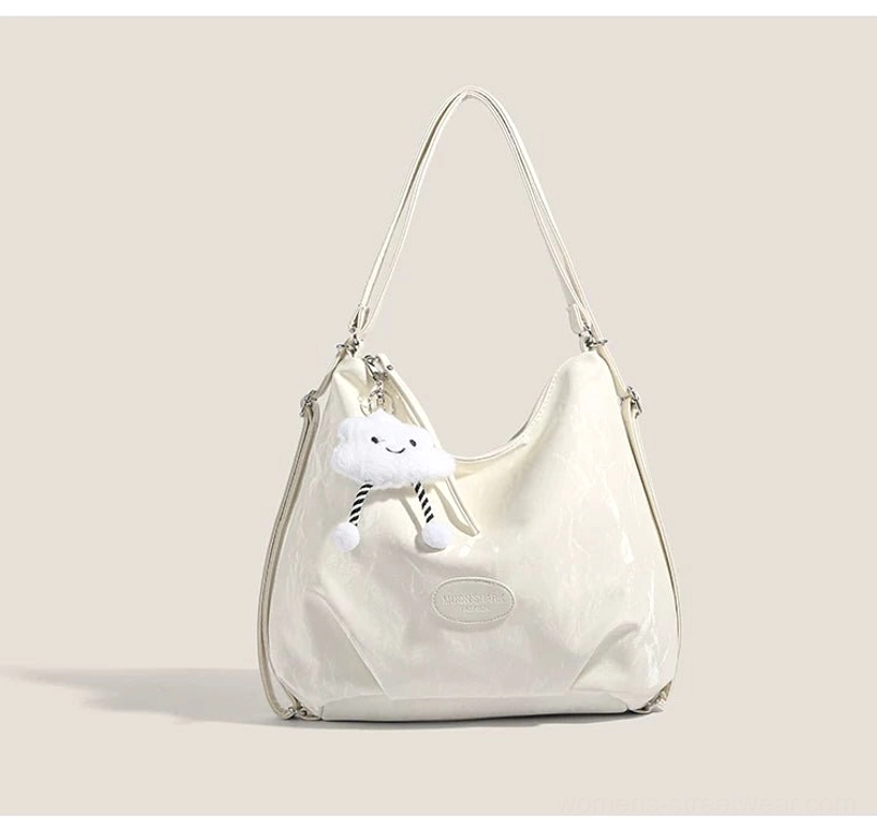 Off white cloud charm crinkle convertible hobo shoulder bag with soft plush cloud pendant front three quarter view