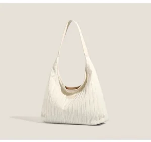 White pleated canvas hobo shoulder bag front three quarter view showing vertical quilted texture and shoulder strap