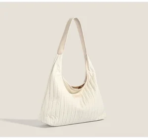 White cloud pleated canvas hobo shoulder bag in a left three quarter studio view with a soft curved silhouette