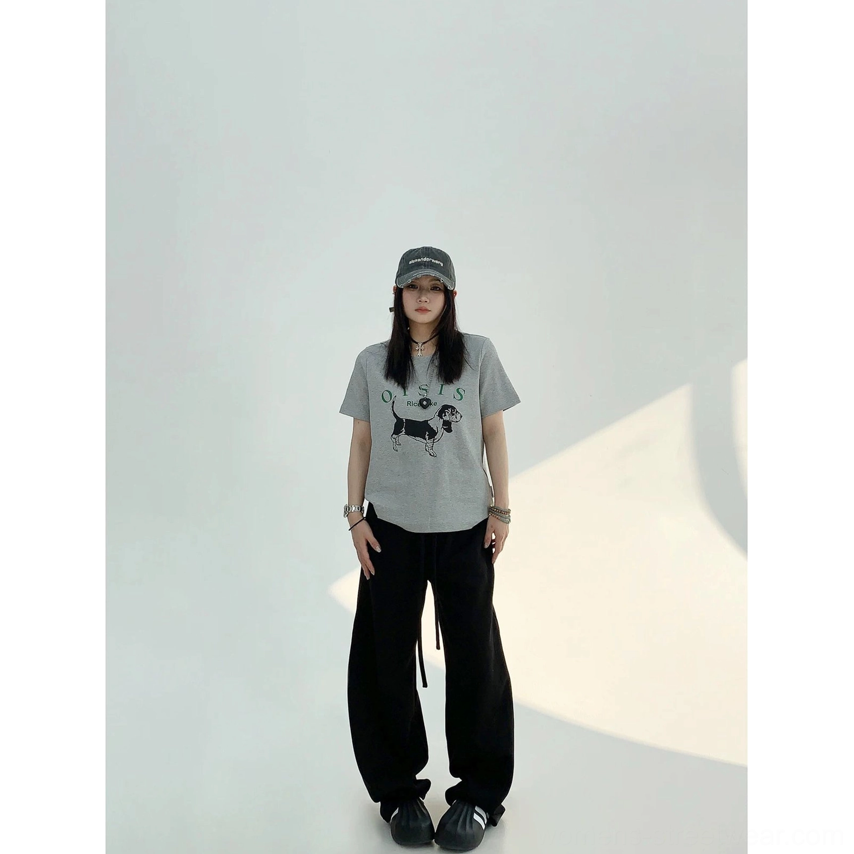 Black high-waist wide-leg streetwear sweatpants styled with a graphic tee and baseball cap for a relaxed urban look