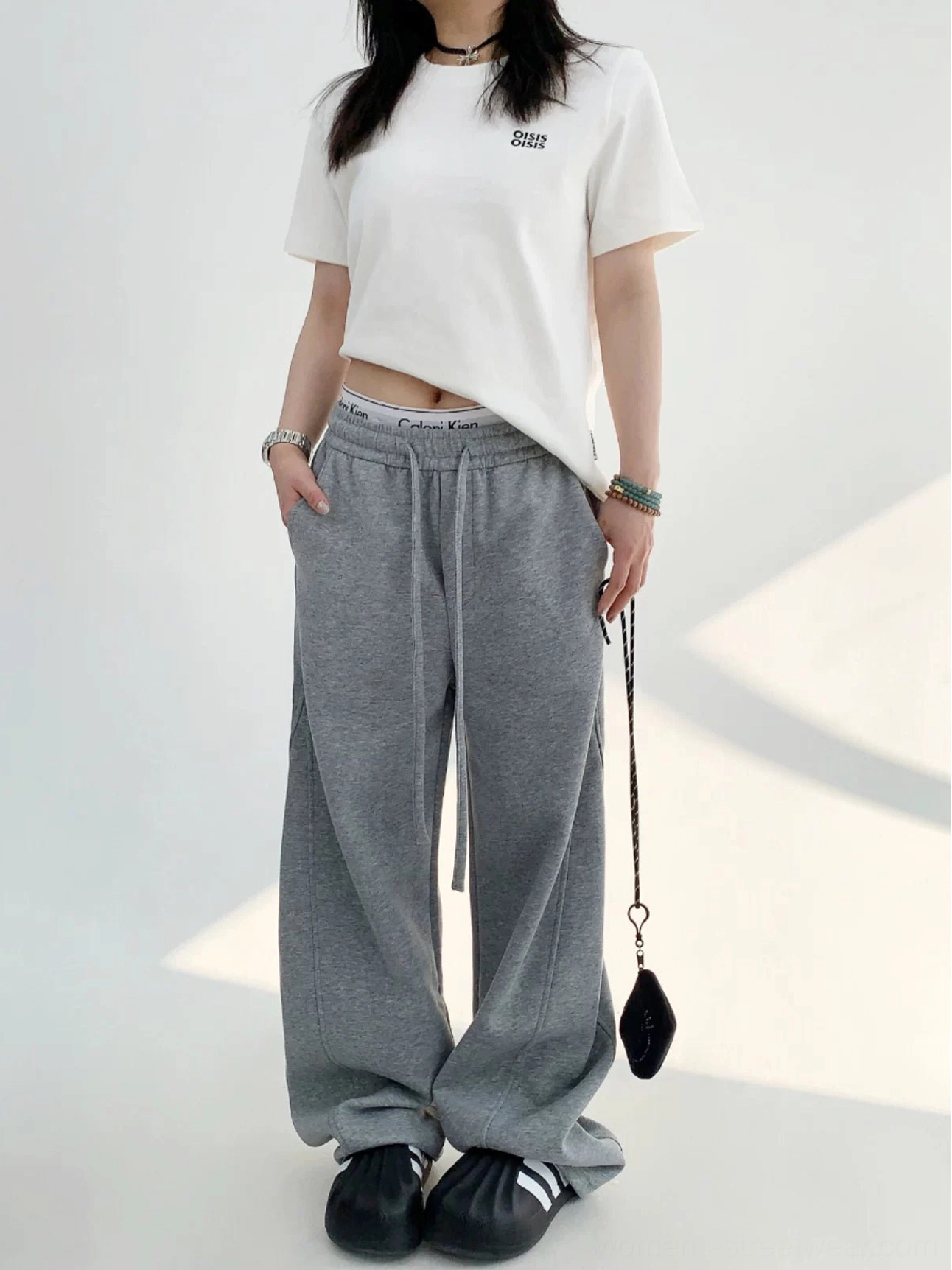 Gray cotton fleece wide-leg sweatpants with side pockets and long relaxed streetwear fit styled with a cropped white top