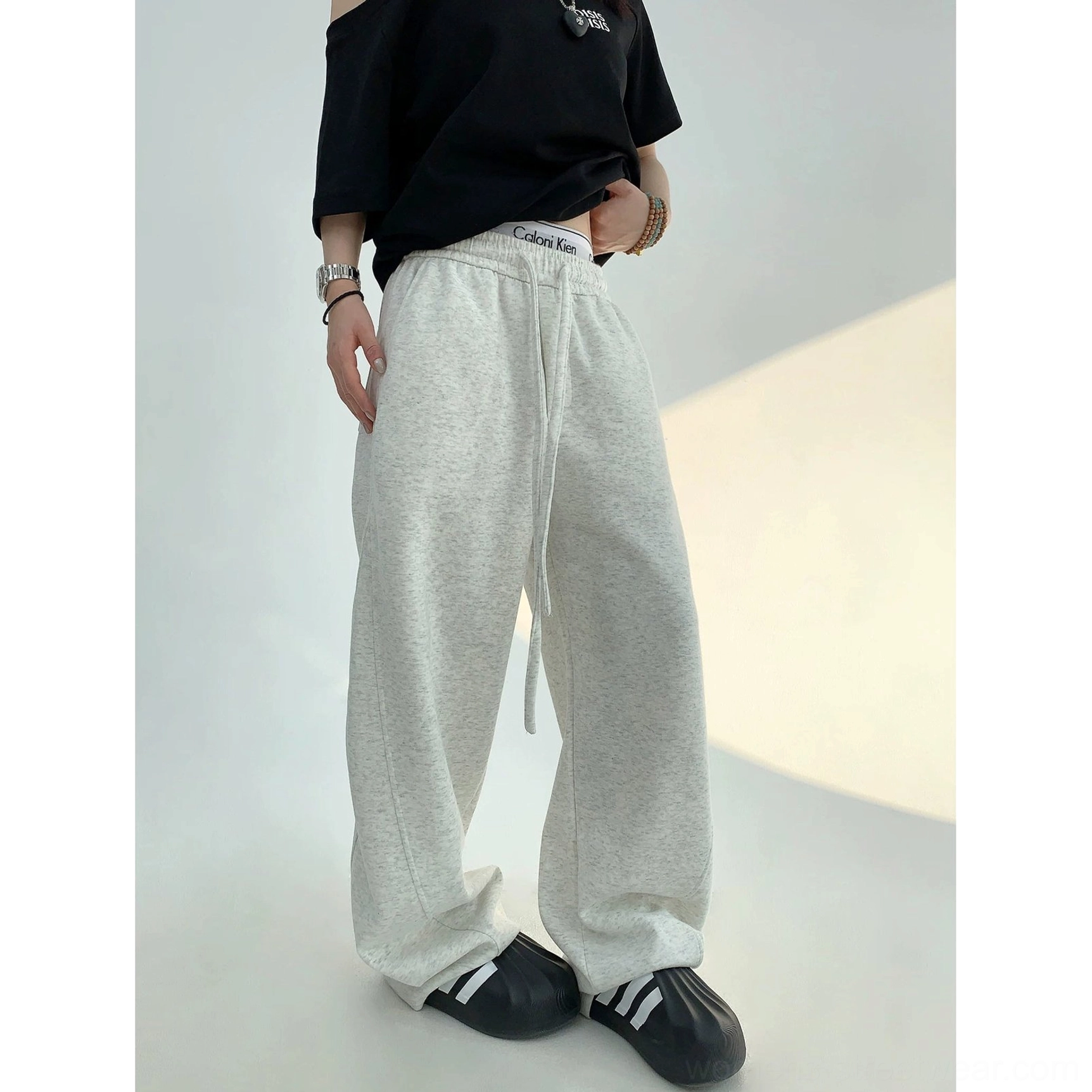 Light gray wide-leg streetwear sweatpants with adjustable drawstring waistband paired with a cropped black top