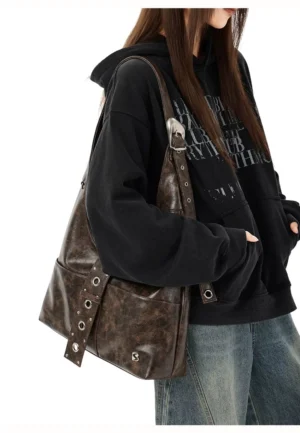 Coffee brown distressed faux leather hobo shoulder bag side view with adjustable silver grommet strap and buckle hardware