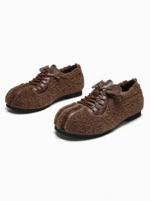 Pair of coffee brown faux shearling lace-up flats with fuzzy upper, contrast leather-style trim, split toe, and flat black soles