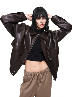 Coffee brown oversized PU leather streetwear jacket front view styled with black cropped top and khaki drawstring trousers