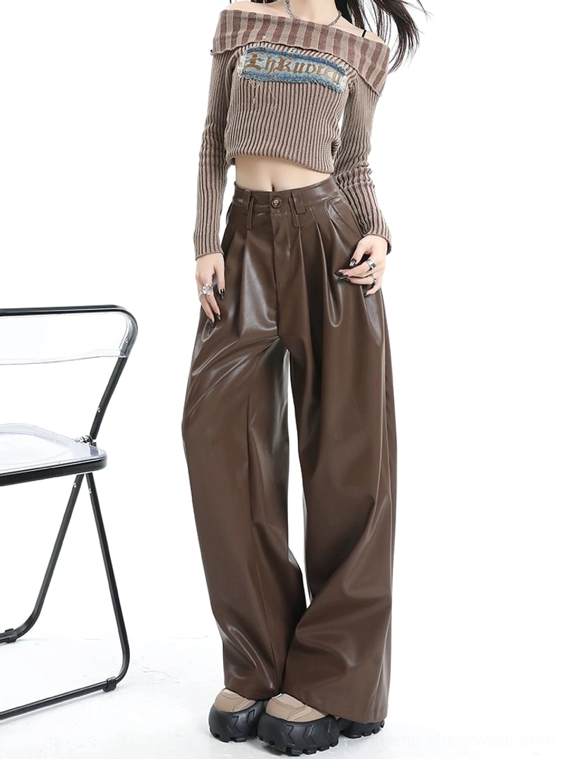 Front view of coffee brown pleated PU leather wide-leg pants with high waist glossy finish and platform shoe styling