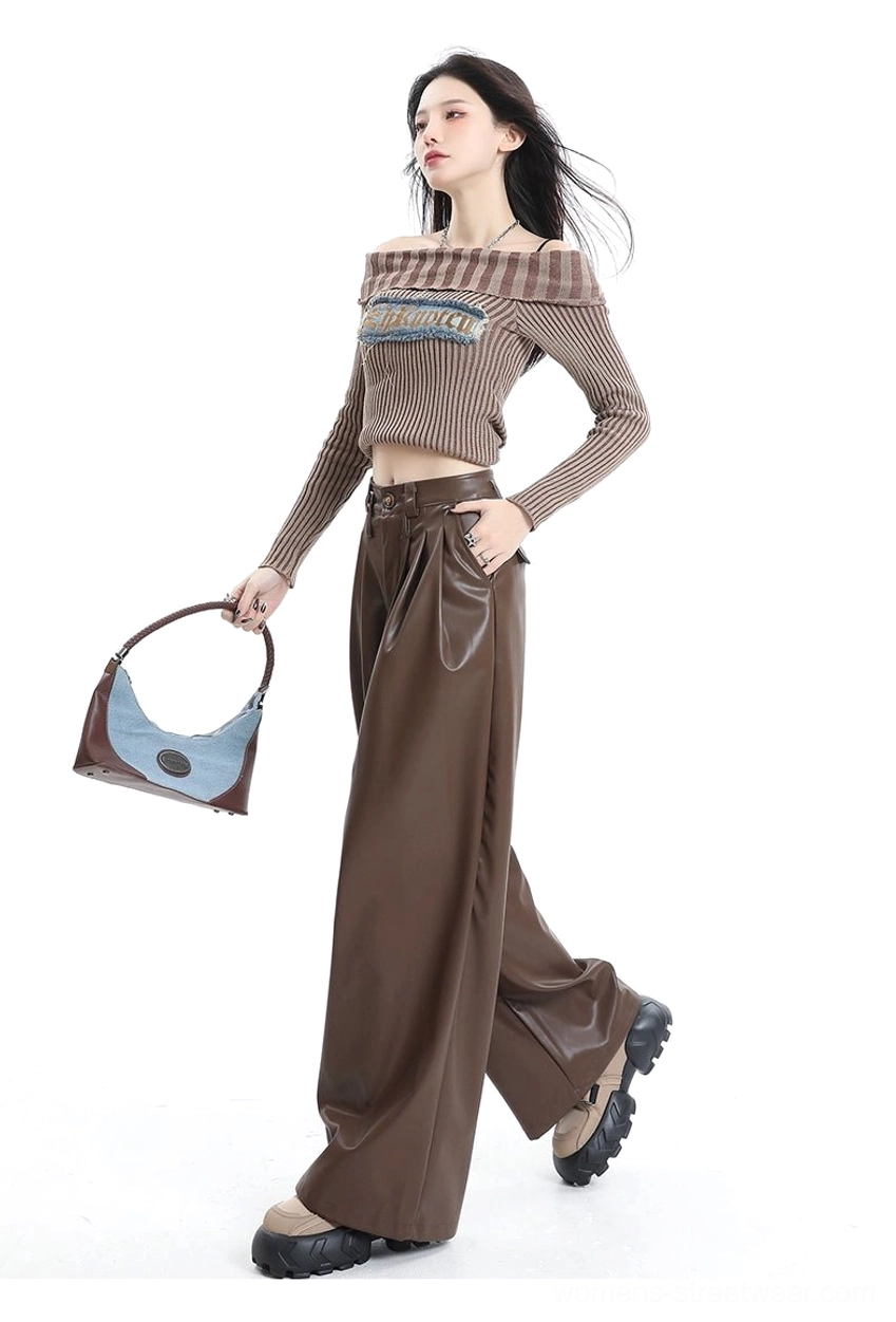 Side walking view of coffee brown pleated wide-leg PU leather streetwear pants with fluid drape and platform footwear