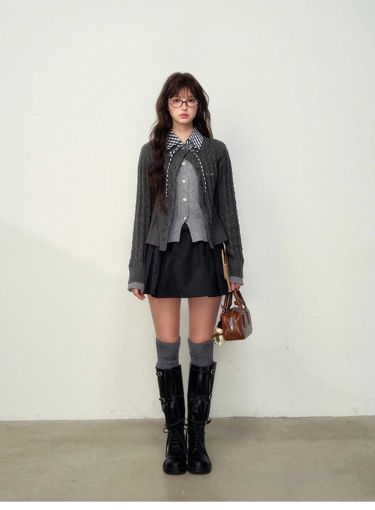 College gray button front cable knit cardigan with black pleated mini skirt in a Korean preppy streetwear outfit