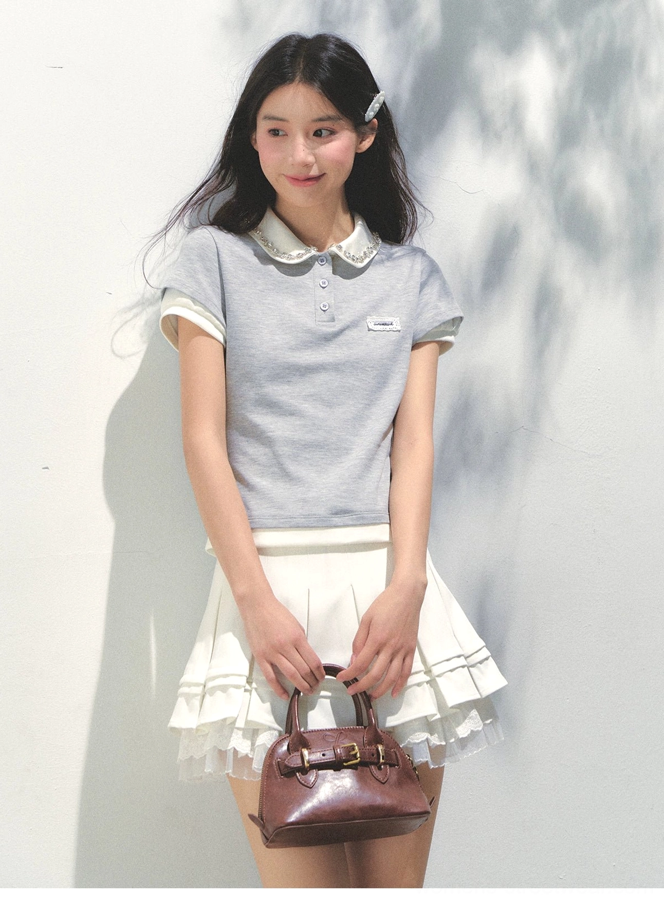 College gray lace collar cotton polo top styled with a white ruffled tennis skirt in Korean preppy fashion