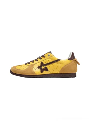 Yellow suede low-profile star trainers shown in a left side studio view with dark brown star logo, brown laces, contrast rubber outsole, and heel pull tab