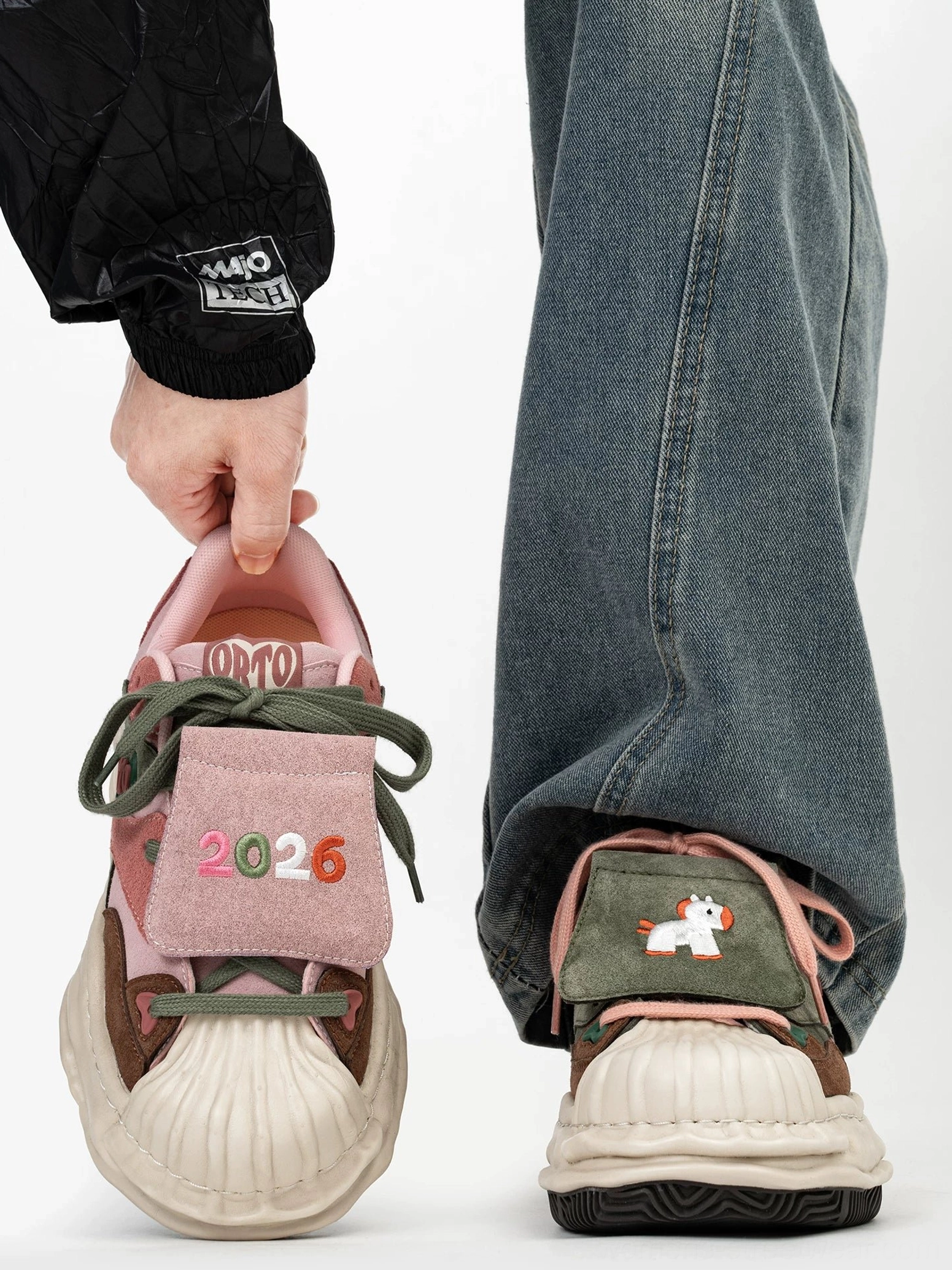 Color block duckling patch low top sneakers with pink suede tongue, 2026 embroidery, green laces, rounded shell toe, and chunky cream lift sole
