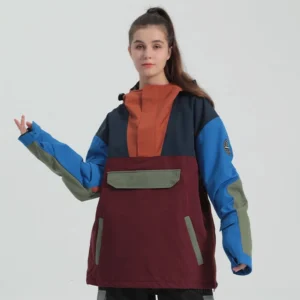 Three-quarter view of a hooded color block snowboard anorak jacket with front utility pocket side zipper details and oversized gorpcore streetwear silhouette