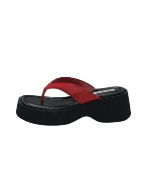 Black chunky platform flip-flops with red suede toe strap and sculptural wedge sole