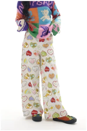 Back view of colorful heart print wide leg streetwear pants styled with a color block knit sweater and white sneakers
