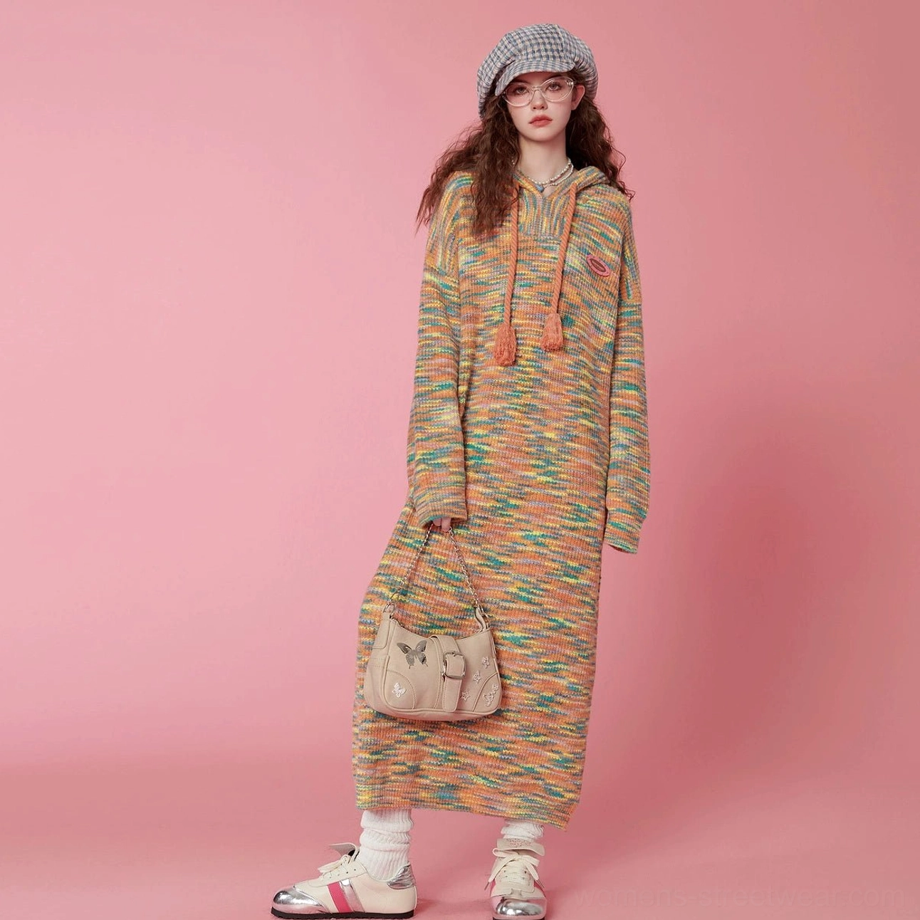 Full body front view of a colorful space-dyed hooded knit midi dress with tassel drawstrings, shoulder bag, sneakers, and socks