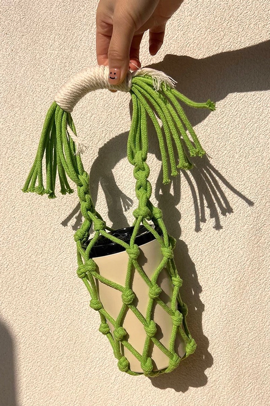 Colorful macrame water bottle holder showcasing cotton rope texture, tassel decoration, and hands-free carrying design