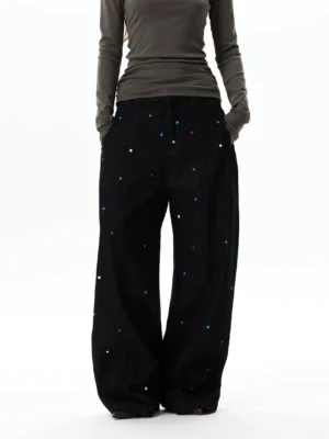 Rear view of oversized black balloon jeans with scattered multicolor rhinestones, wide-leg denim silhouette, and relaxed streetwear fit