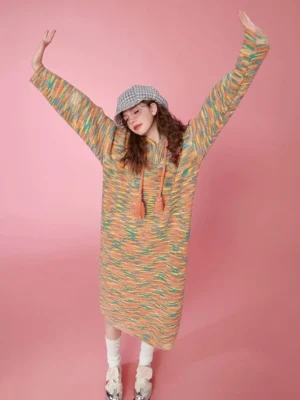 Full body view of a colorful space-dyed rainbow knit midi dress with hood tassel drawstrings, relaxed sleeves, and ribbed texture