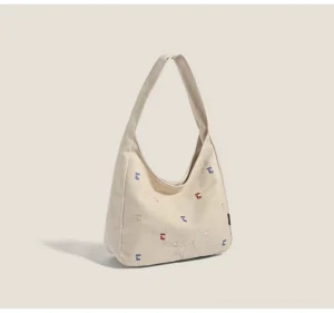 Khaki confetti embroidered canvas hobo shoulder bag in a front three quarter studio view