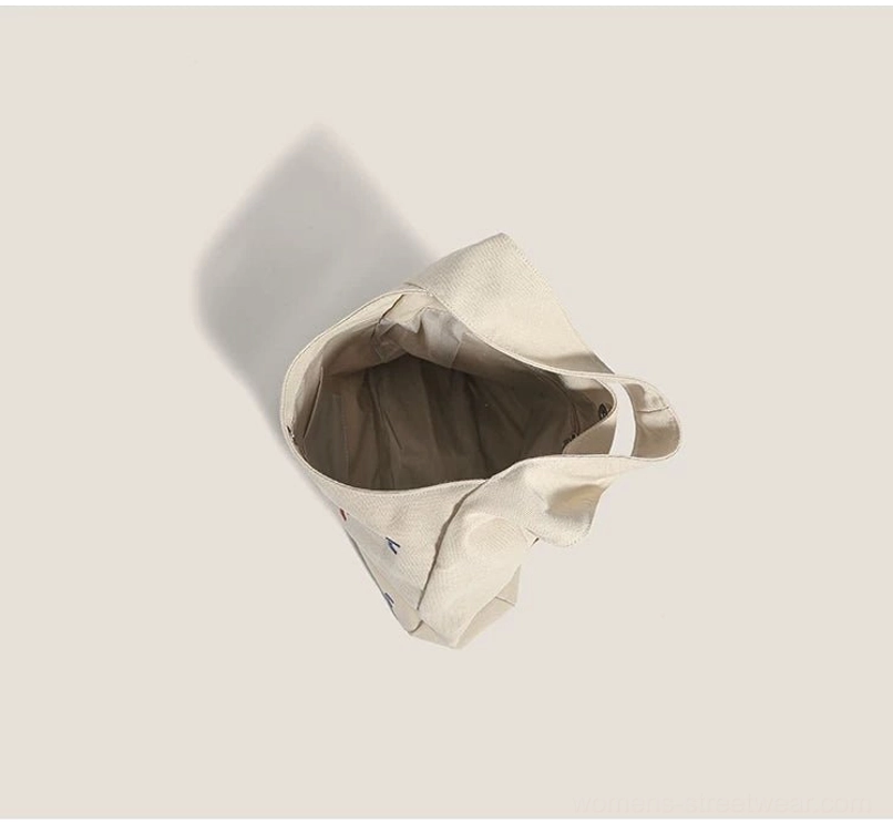 Interior top view of khaki confetti embroidered canvas hobo shoulder bag with open main compartment