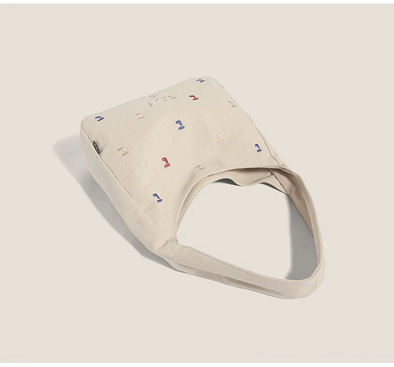 Top flat lay of khaki confetti embroidered canvas hobo bag showing its rounded shape and opening