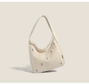 Khaki canvas hobo shoulder bag with colorful confetti stitch embroidery and curved underarm silhouette