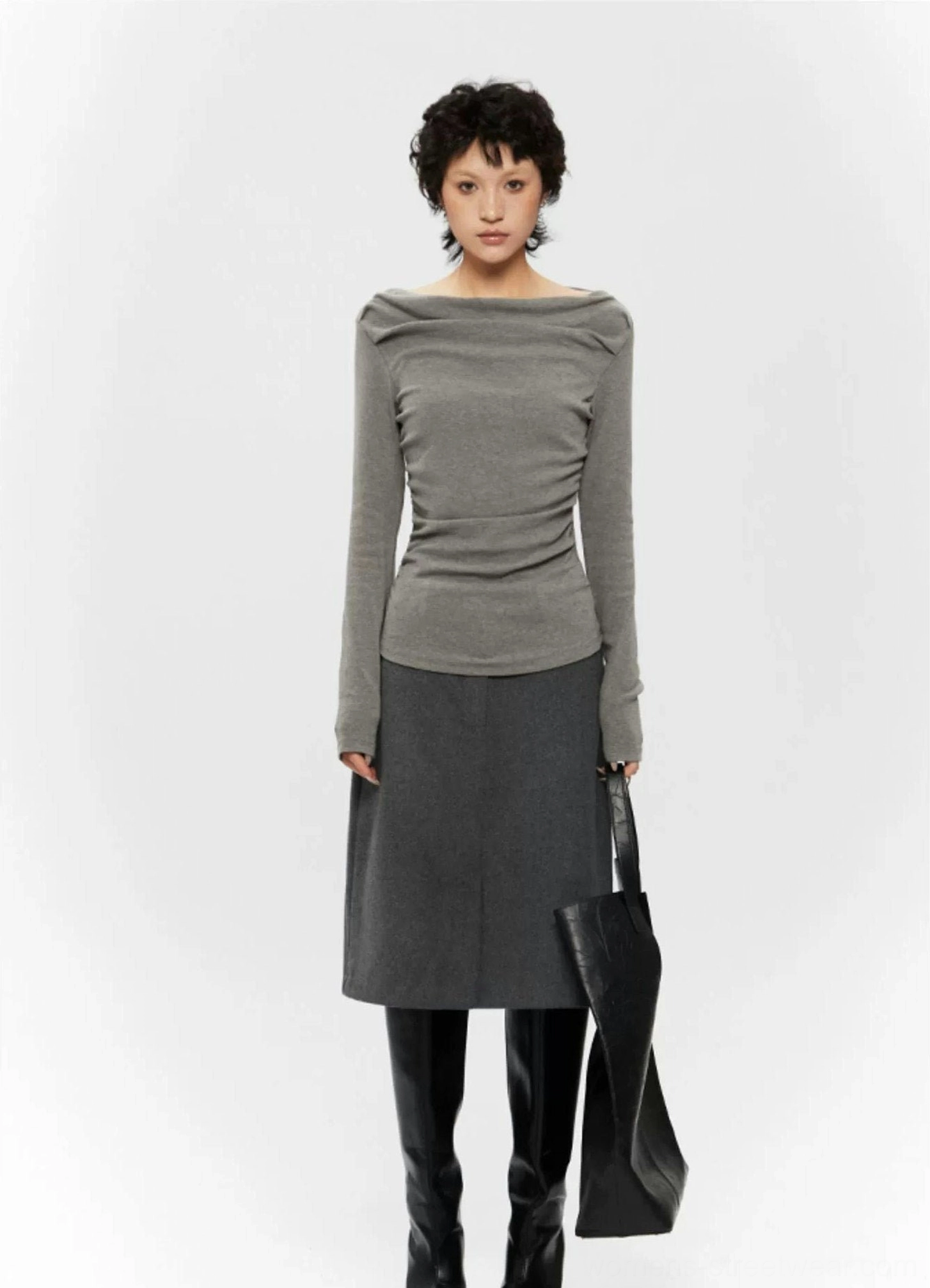 Contemporary feminine streetwear top with an asymmetrical off-shoulder neckline, ruched body, and slim sleeves