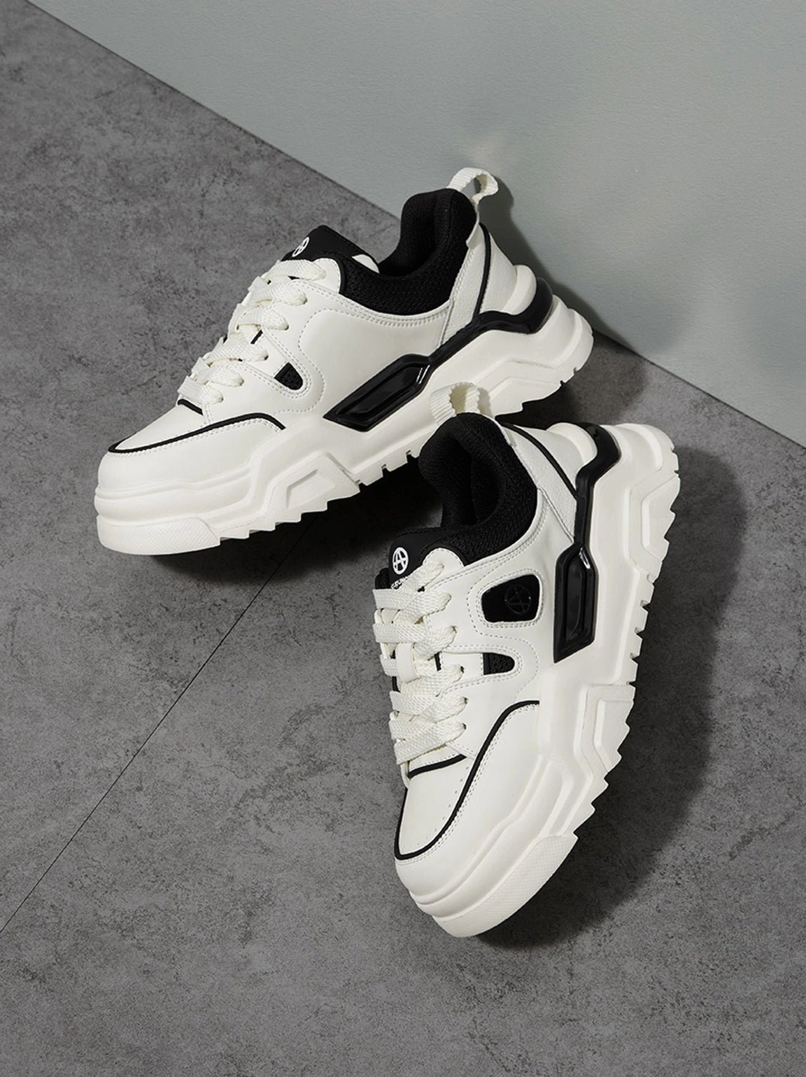 Low side view of contrast cutout lug sole platform sneakers against a studio wall