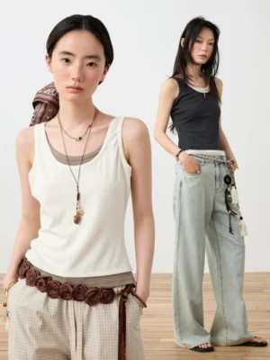 Two-tone layered scoop neck fitted tank tops styled with retro wide leg pants in an indoor streetwear studio