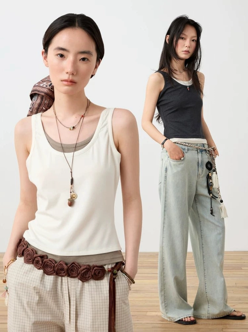 Two-tone layered scoop neck fitted tank tops styled with retro wide leg pants in an indoor streetwear studio