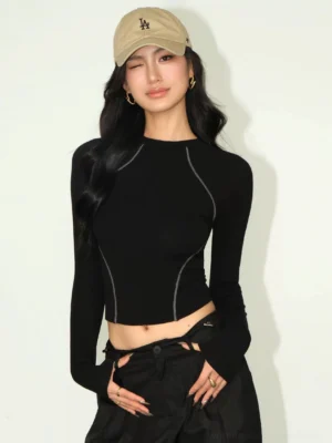 Black contrast stitch cropped long sleeve tee front view worn with black cargo skirt and khaki baseball cap streetwear styling