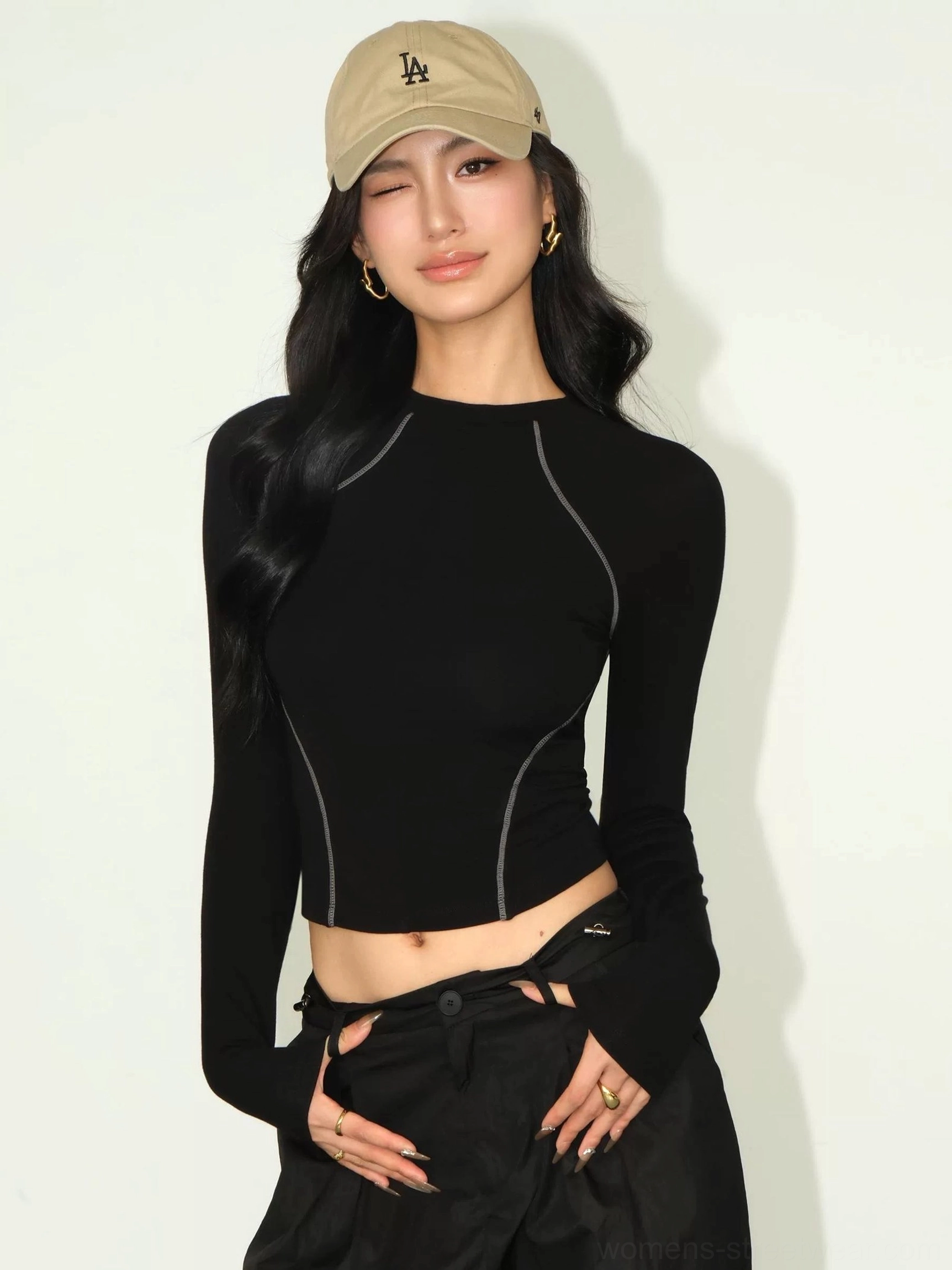 Black contrast stitch cropped long sleeve tee front view worn with black cargo skirt and khaki baseball cap streetwear styling