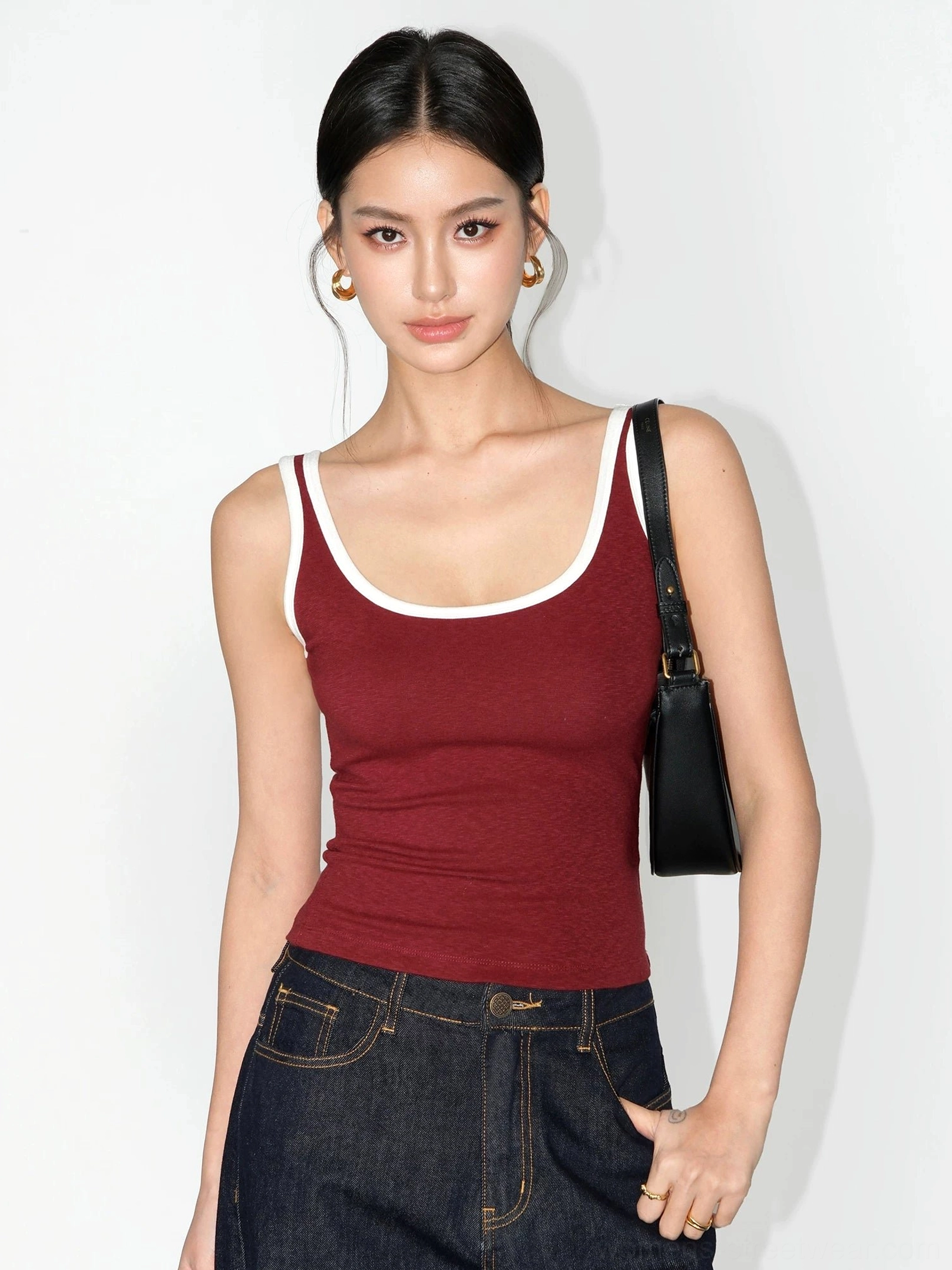 Burgundy contrast trim scoop neck ribbed knit tank top styled with dark wash jeans and a black shoulder bag