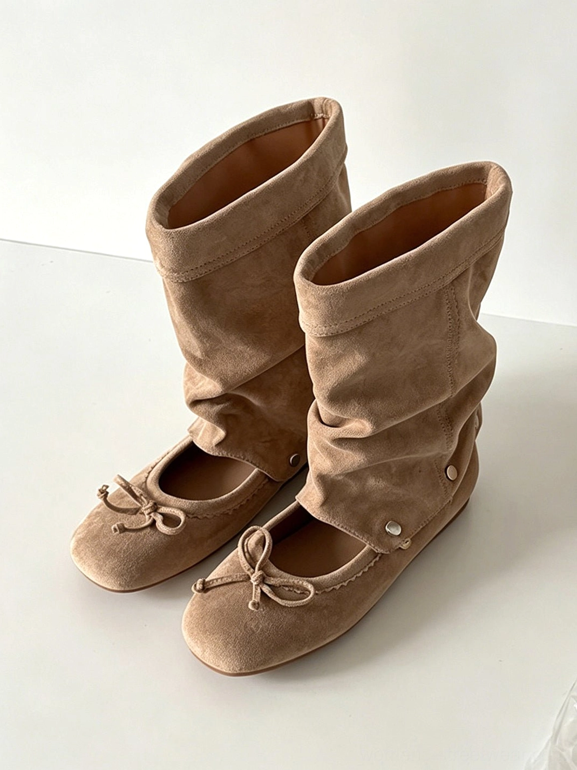 Pair of apricot brown slouchy sandal boots with detachable toe bows and soft folded shafts