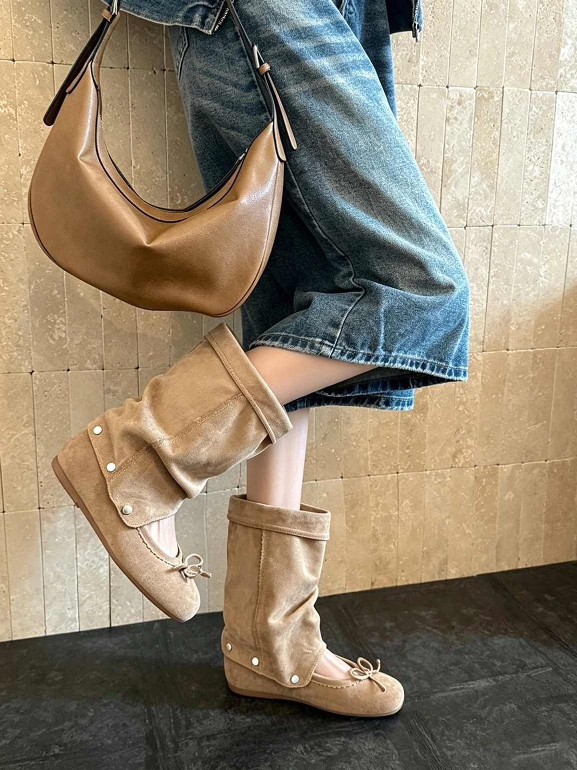 Rear side view of convertible apricot bow-wrap slouchy sandal boots styled with a denim midi skirt