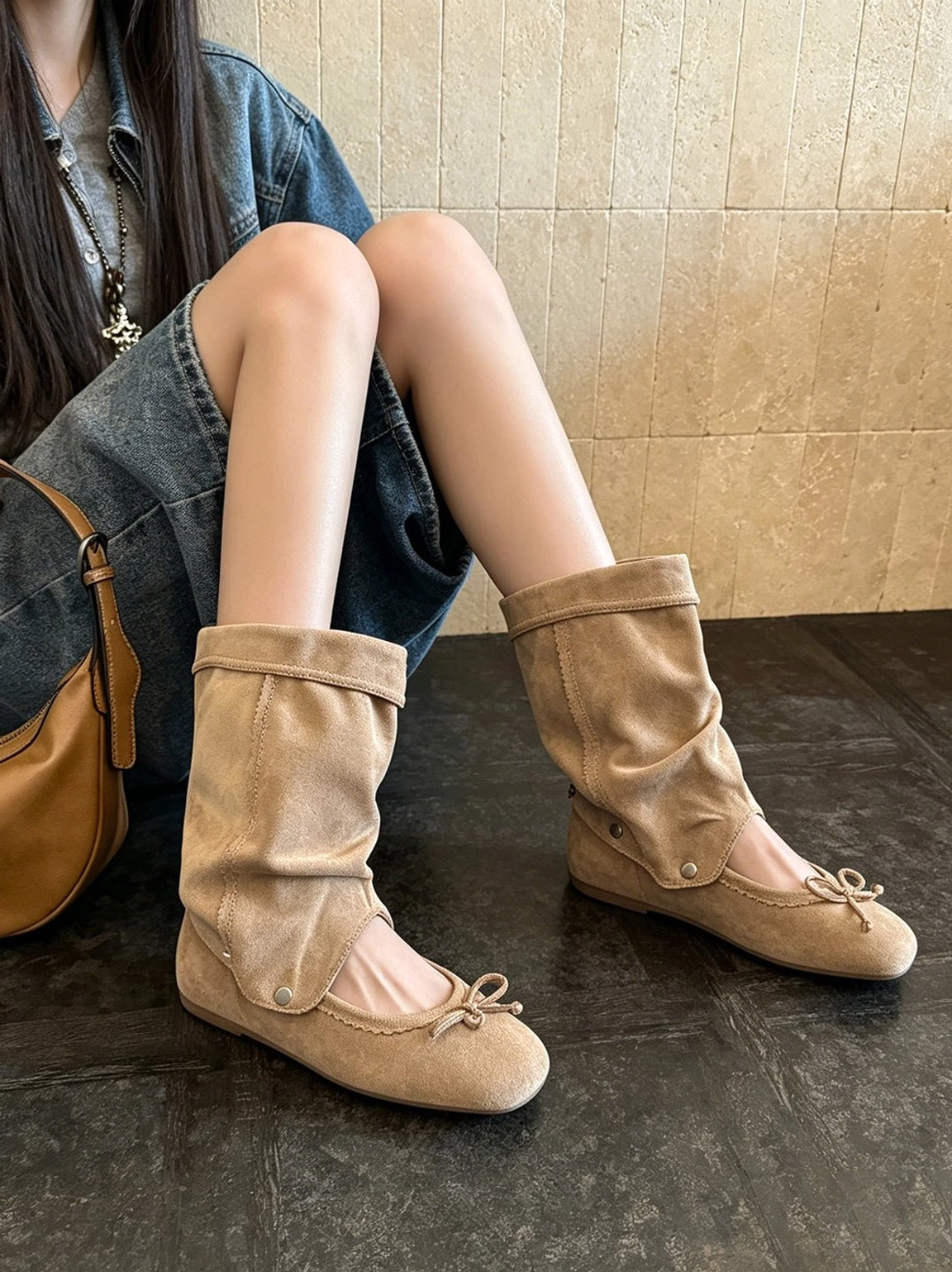Side view of apricot slouchy bow sandal boots with folded mid-calf shaft and subtle metal stud details