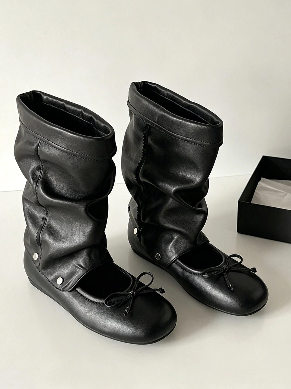 Convertible bow-wrap slouchy sandal boots showcasing the low flat sole and rounded footwear profile