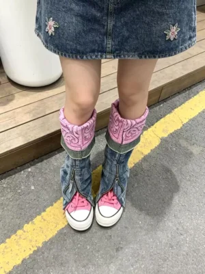 Rear street style view of pink convertible denim shaft colorblock canvas boots worn with a denim mini skirt on a road