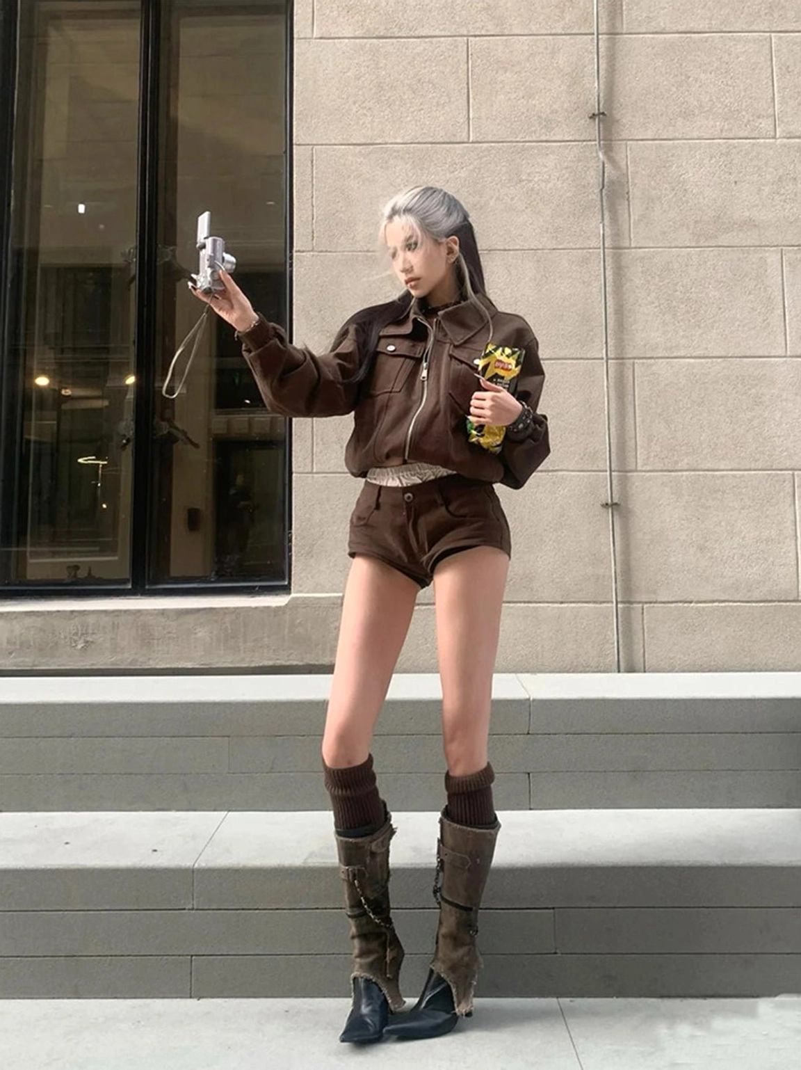Front three-quarter view of distressed shaft pointed stiletto boots with buckle details and avant-garde streetwear styling