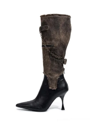 Black pointed toe stiletto boots with detachable distressed brown shaft, chain decoration, and buckle accents shown from the front