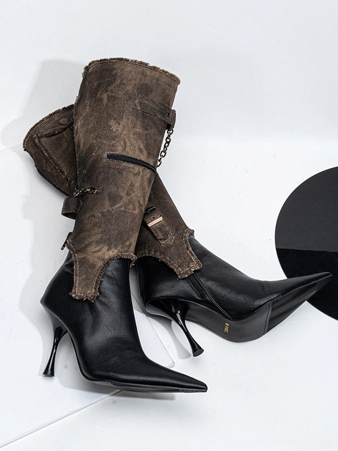 Fashion-forward black stiletto boots with detachable distressed shaft, pointed toe, and industrial buckle accents